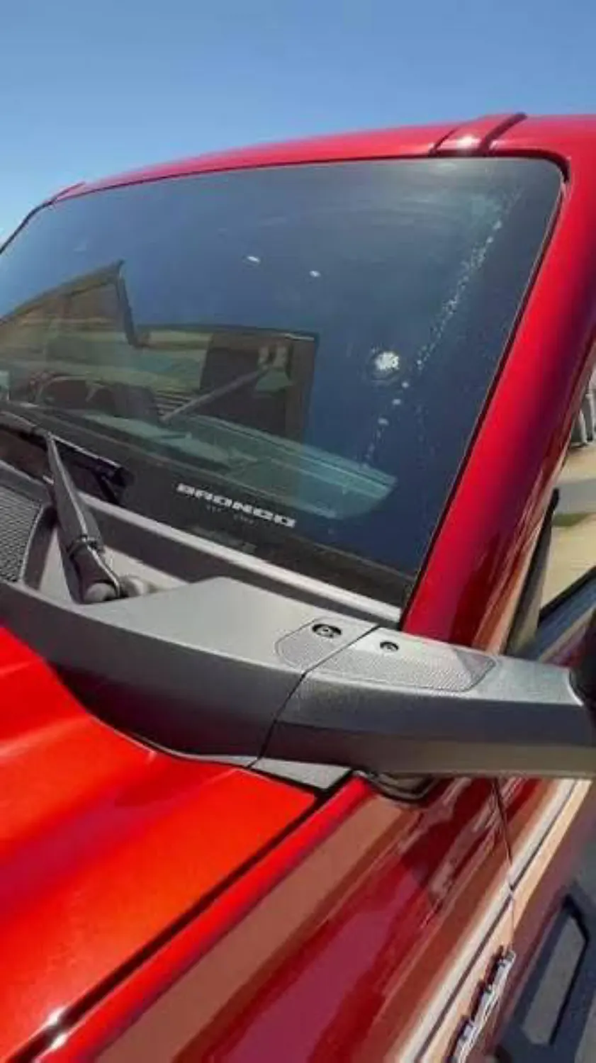 A rock chip in a red Ford Bronco windshield, before mobile chip repair